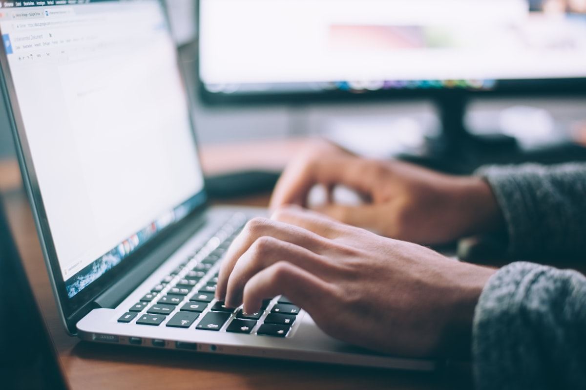 Seseorang mengetik di laptop untuk berbagi tautan referral