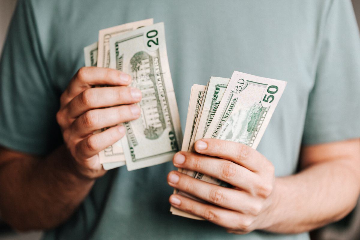 Seseorang memegang uang tunai untuk deposit